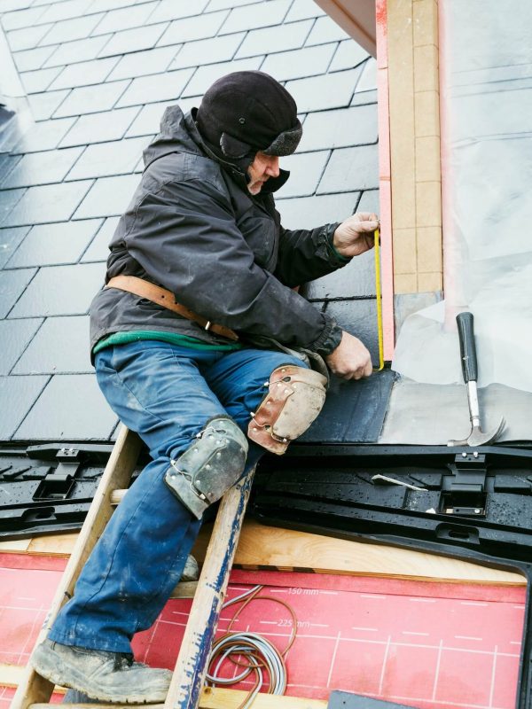 a-man-at-the-top-of-a-ladder-on-a-house-roof-fixing-tiles-on-a-dormer-roof-1-1.jpg